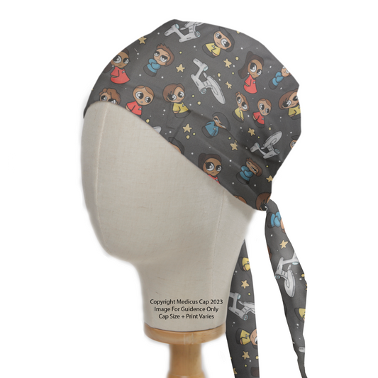 Displayed on a mannequin, the Medicus Space Cartoon Star Trek Kawaii Scrub Cap features adorable characters, spaceships, and stars on a dark background with a tie-back design.