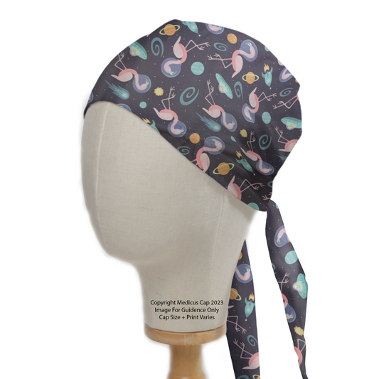 Space Flamingoes Travel Scrub Cap from Medicus Scrub Caps, featuring a cosmic flamingo pattern on a dark background with planets and stars.