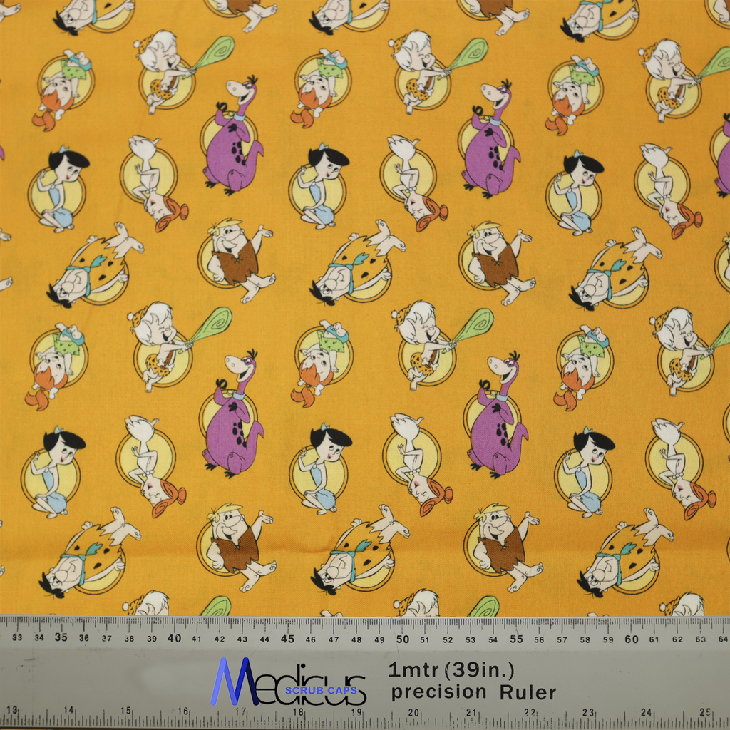 An orange Medicus Scrub Cap features Flintstones characters, cavemen, and dinosaurs, with a ruler ensuring precise fit for this fun, nostalgic design.