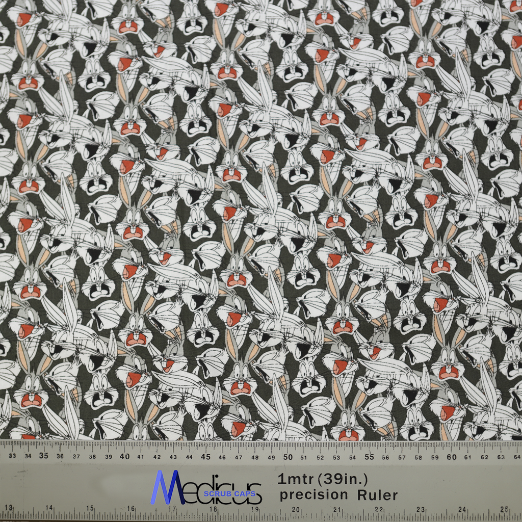 The Medicus Scrub Caps TV Cartoon Looney Tunes Bugs Bunny Scrub Cap features expressive Bugs Bunny faces on a dark gray background, with a ruler for scale.