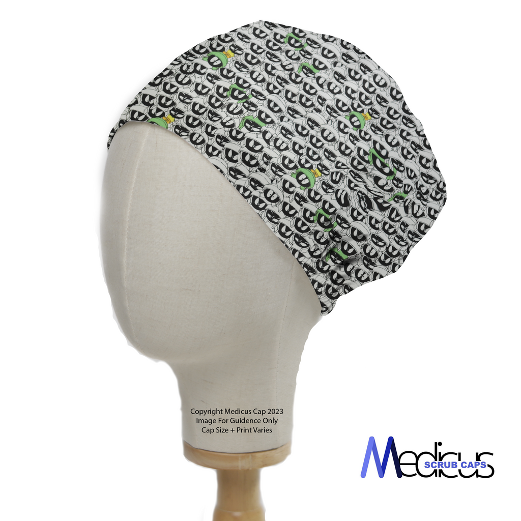 A mannequin displays a Medicus Scrub Caps product: the TV Cartoon Looney Tunes Marvin Martian Crowd Scrub Cap, featuring a monochrome design with green and yellow accents.