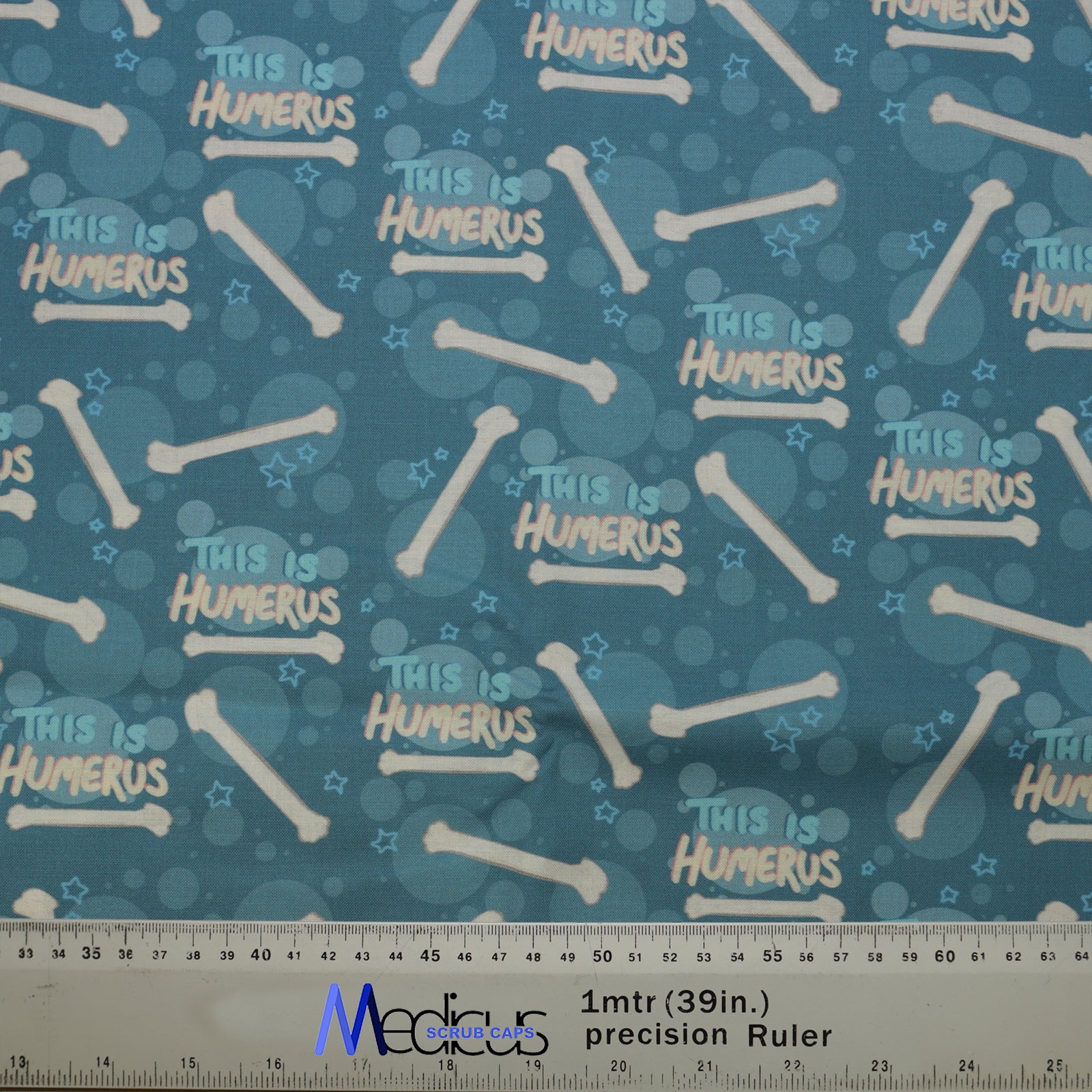The Medicus Scrub Caps This Is Humerus Bones Scrub Cap features cartoon bones and "This is humerus" text in blue tones, accented with stars.
