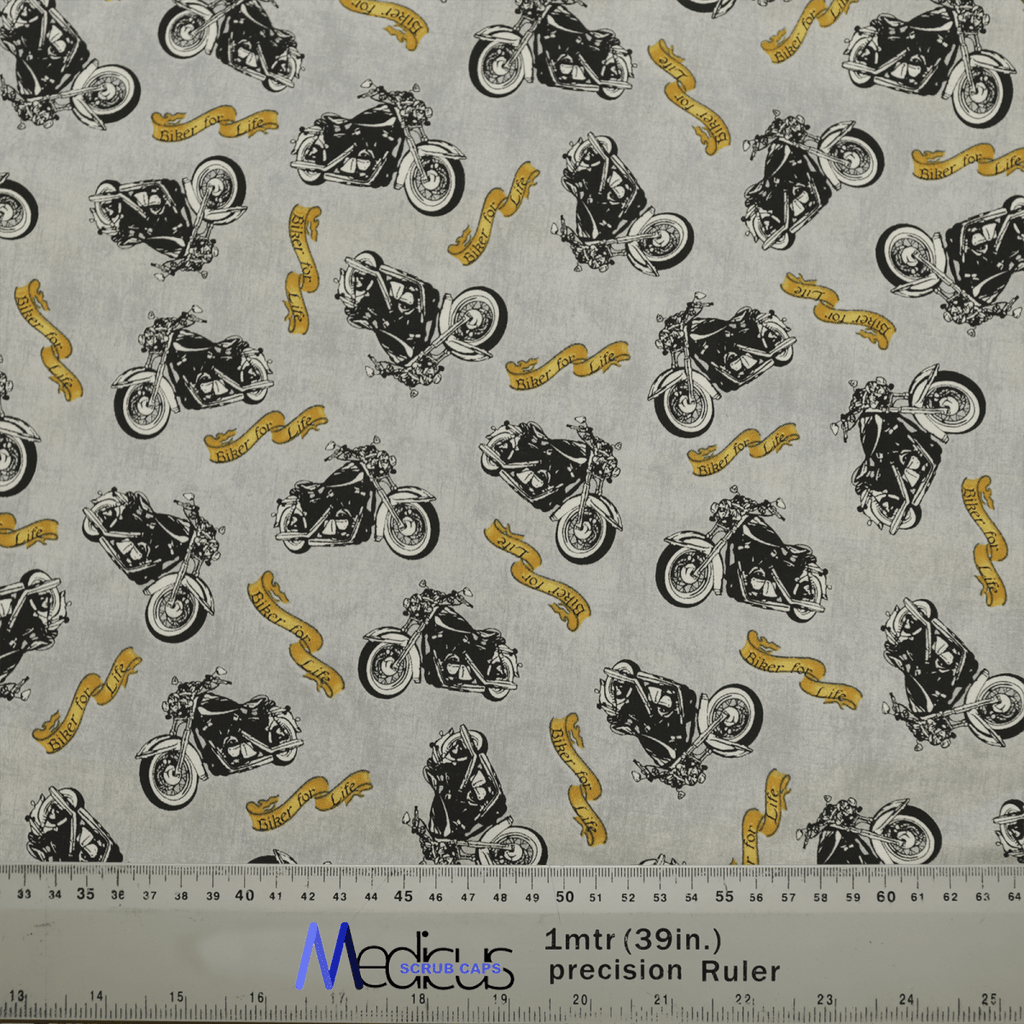 Black motorcycles and yellow ribbons with text adorn this gray Bike Biker For Life Scrub Cap by Medicus Scrub Caps, perfect for crafting a medical comfort cap. The fabric includes precise measurements for accuracy, displayed in inches and centimeters with a clear ruler on the bottom.