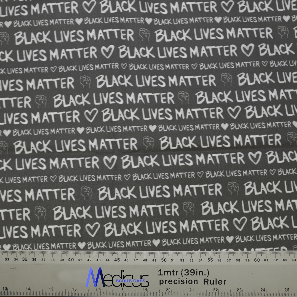 The Black Lives Matter BLM Scrub Cap by Medicus Scrub Caps is a black fabric with Black Lives Matter and white-printed hearts. It includes a one-meter precision ruler at the bottom featuring the Moore SpaceSolutions logo.