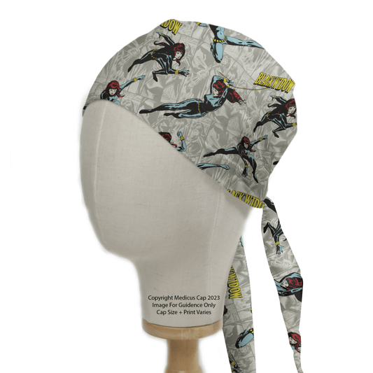 A mannequin displays the eco-friendly Black Widow Superhero Scrub Cap by Medicus Scrub Caps, featuring a comic-themed pattern with Black Widow in various poses on a light background.