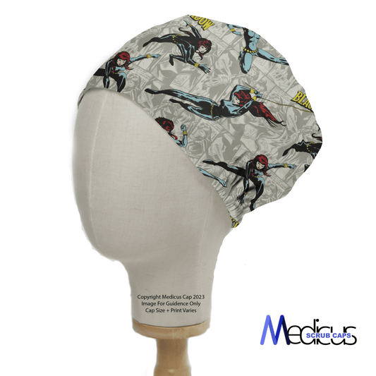 A mannequin head models the Medicus Scrub Caps Black Widow Superhero Scrub Cap, featuring comic book characters in dynamic poses. The cap has a gray background with vibrant figures and the brand logo in the corner, seamlessly combining style and function.