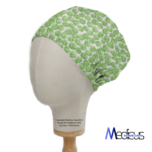 The mannequin head wears a stylish and comfy Brussel Sprouts Scrub Cap with a green leaf-like pattern by Medicus Scrub Caps, noting that cap size and design may vary.