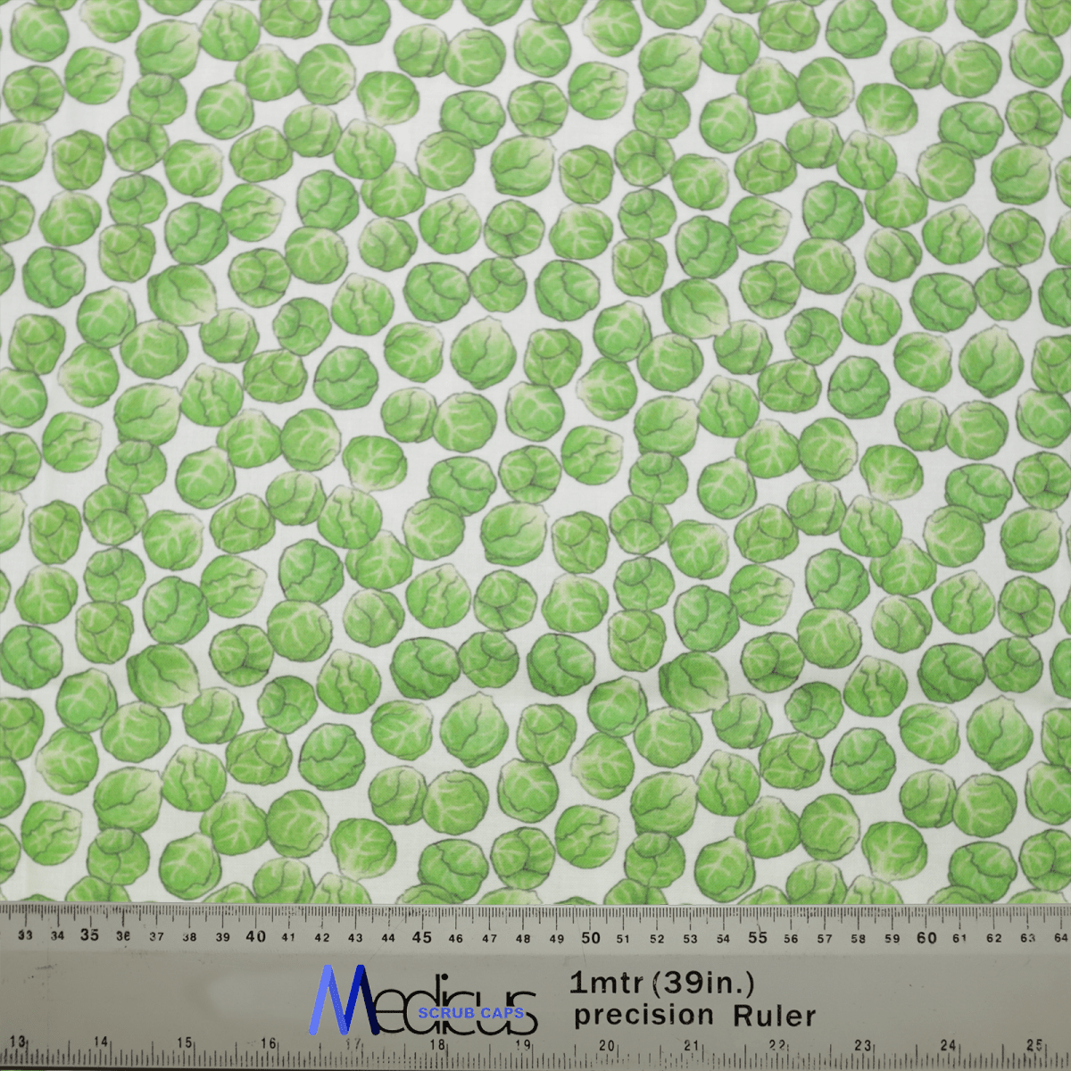 The Medicus Scrub Caps Brussel Sprouts Scrub Cap showcases a chic design with green Brussels sprouts on a light background. A Medoca 1mtr (39in.) precision ruler provides an accurate size reference, ideal for achieving a perfect fit, whether for garments or the scrub cap itself.