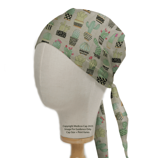 A mannequin head displays the eco-friendly Cactus #1 Abstract Pots Scrub Cap by Medicus Scrub Caps, featuring green and pink cactus designs. The neutral background enhances its vibrancy. Text on the neck notes its for image guidance, with size and print subject to customization.