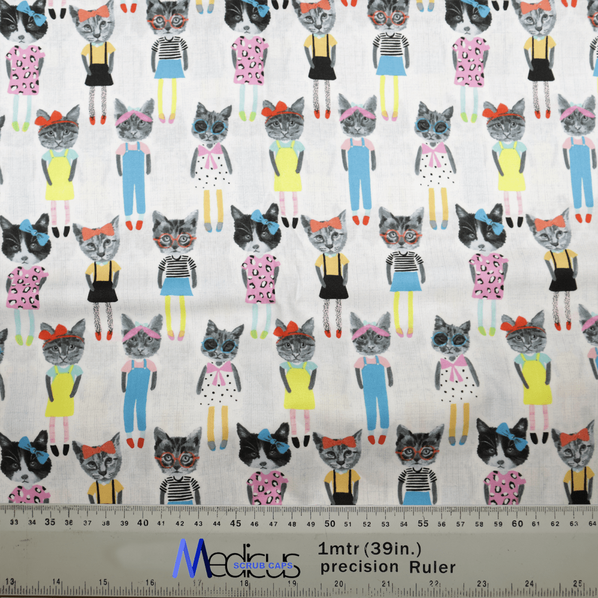 The Cat Cartoon Dress Up Scrub Cap by Medicus Scrub Caps showcases patterned fabric with cartoon cats in colorful outfits, bows, and glasses. Perfect for eco-friendly scrub caps, it includes a 1-meter ruler at the bottom for variety in cat designs.