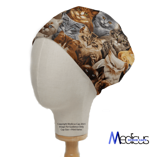 A mannequin head features the Cat Starring Scrub Cap by Medicus Scrub Caps, with playful cat faces on a crisp white base.