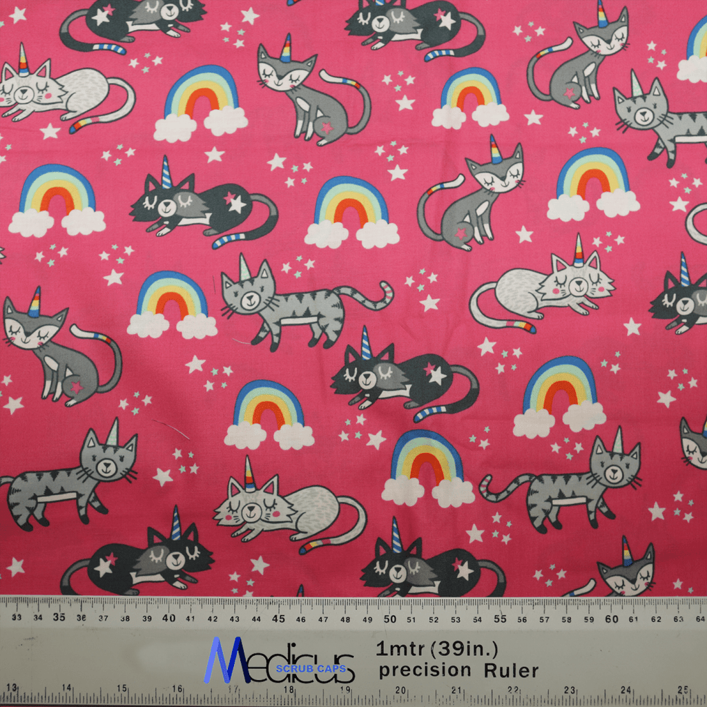 The Cats Unicorn Rainbow Pink Scrub Cap by Medicus Scrub Caps features a pink background with playful gray cats, unicorn rainbows, stars, and clouds. Its comfortable, breathable, and sustainable. A ruler at the bottom shows measurements in inches and meters for scale.