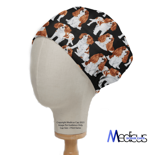 A mannequin head models the Cavalier King Charles Spaniels Dogs Scrub Cap by Medicus Scrub Caps, featuring a pattern of Cavalier King Charles Spaniels set against a black background.