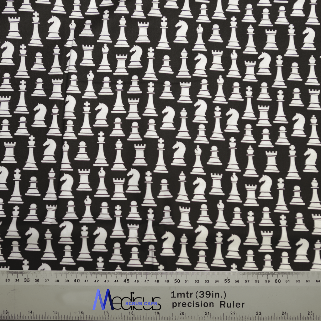 The Medicus Scrub Caps Chess Pieces Classic Black + White Scrub Cap features white chess pieces, like kings and knights, on black. A ruler at the bottom provides inch and centimeter measurements, celebrating strategic brilliance.
