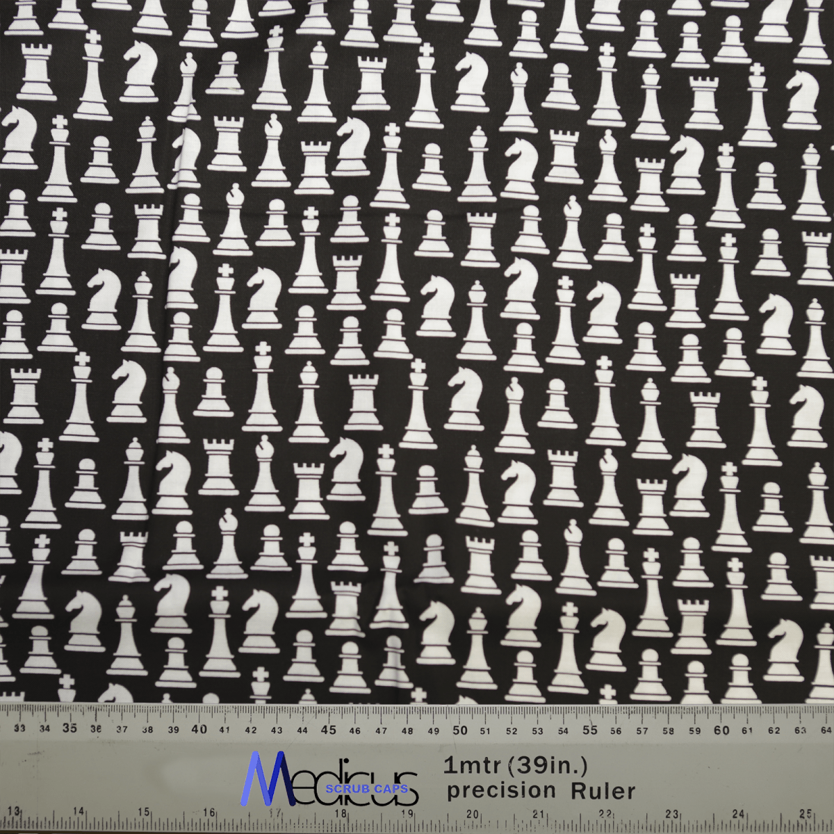 The Medicus Scrub Caps Chess Pieces Classic Black + White Scrub Cap features white chess pieces, like kings and knights, on black. A ruler at the bottom provides inch and centimeter measurements, celebrating strategic brilliance.