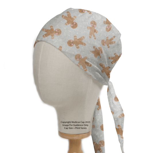 The Medicus Scrub Caps Christmas Gingerbread Scrub Cap is an eco-friendly white cap with a festive pattern of gingerbread men, displayed on a mannequin to highlight its delightful design and snug fit.