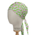 A mannequin head sports the Medicus Scrub Caps Christmas Pickle Rick Inspired Scrub Cap, featuring a playful pattern of green pickles and red chili peppers, adding a whimsical touch ideal for medical professionals.
