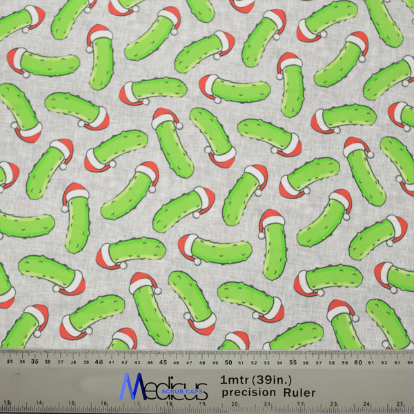 The Christmas Pickle Rick Inspired Scrub Cap by Medicus Scrub Caps features a whimsical design of green pickles in Santa hats, along with a ruler showing both centimeters and inches—a perfect festive touch for medical professionals.