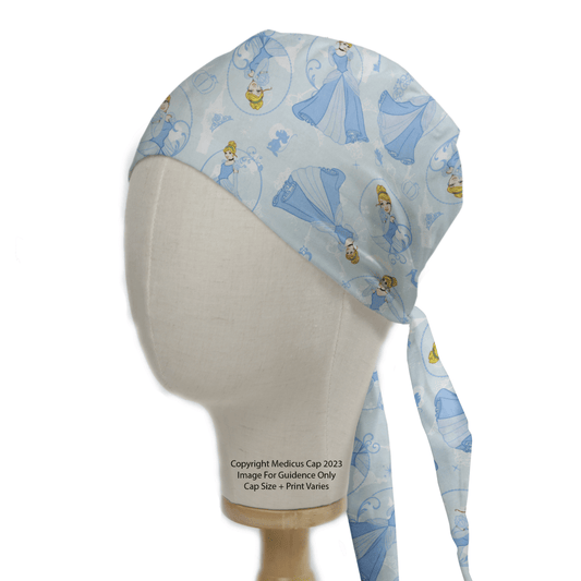 A mannequin head displays an eco-friendly Cinderella Scrub Cap from Medicus Scrub Caps, perfect for healthcare professionals, featuring animated princesses in blue gowns and tied at the back.