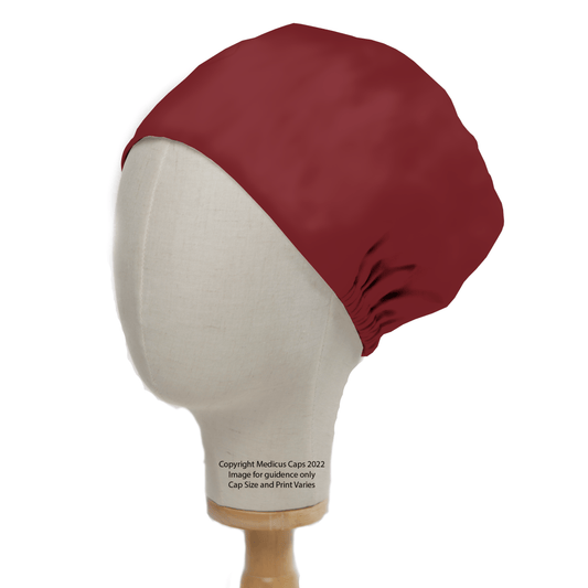 A Classic Plain Claret Red Scrub Cap by Medicus Scrub Caps is shown on a mannequin head in profile against a white background. The text mentions its for guidance only, indicating cap size and print variation while ensuring durable performance.