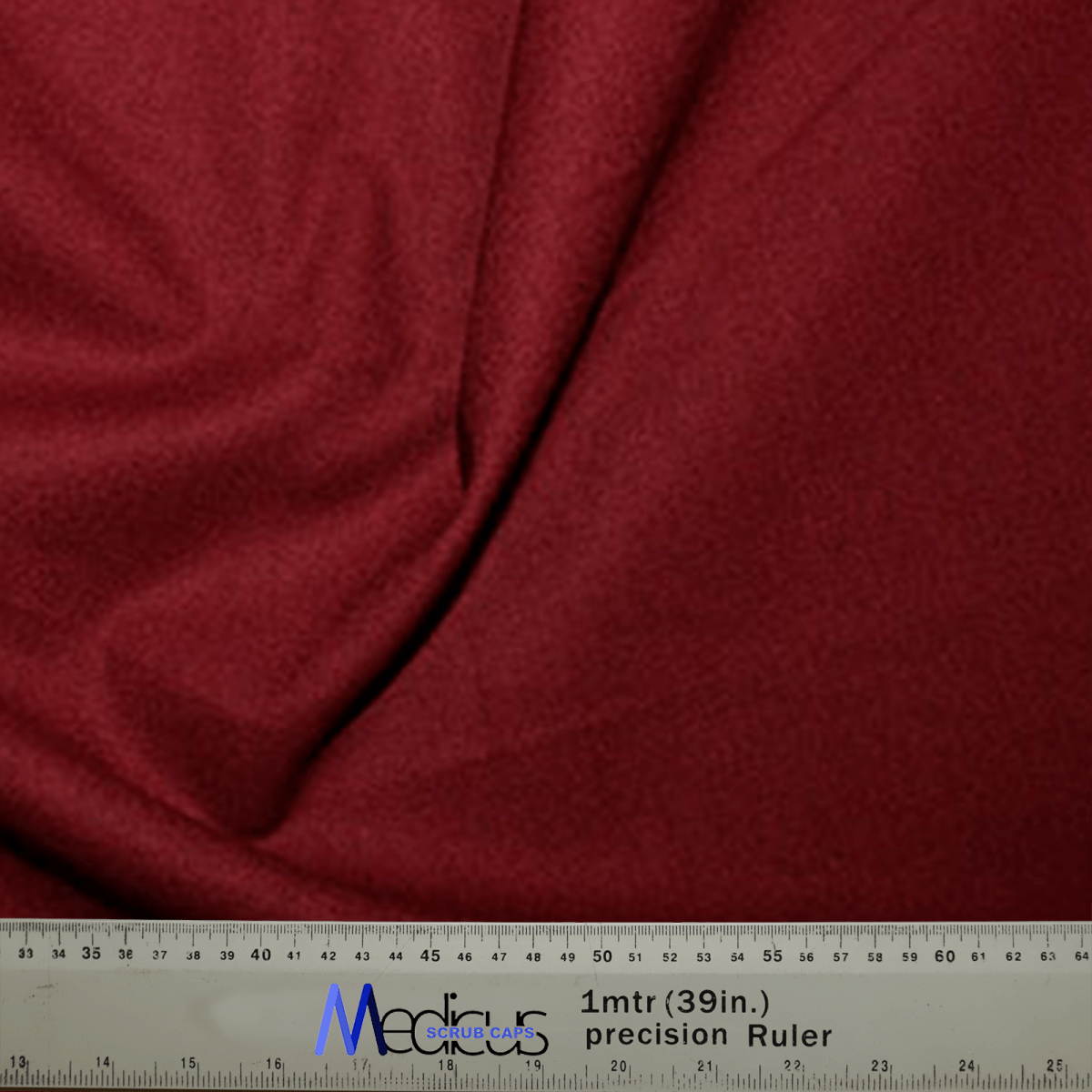 The Classic Plain Claret Red Scrub Cap by Medicus Scrub Caps, resembling durable medical fabric with subtle folds, comes with a Measurement Canada tool at the bottom—perfect for precise needs of medical professionals.