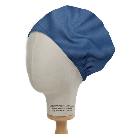 A mannequin head displays a Classic Plain Copen Blue Scrub Cap by Medicus Scrub Caps, highlighting its smooth, hypoallergenic design and gathered back. A label reads: © Medicus Caps 2022. Image for guidance only; cap size and print may vary.