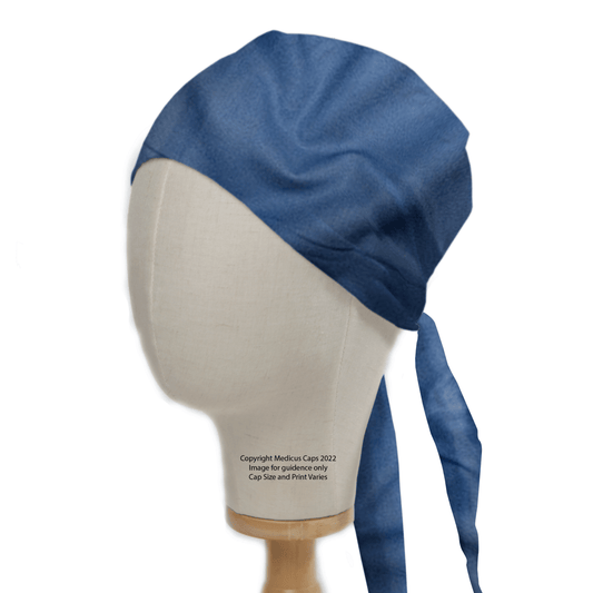 A mannequin head displays a Medicus Scrub Caps Classic Plain Copen Blue Theatre Hat, featuring long ties for a snug, hypoallergenic fit.