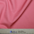 A close-up showcases the coral pink fabric of a Classic Plain Scrub Cap by Medicus Scrub Caps draped over a 39-inch ruler. The soft, textured material accompanies a silver Media precision ruler with blue and black text, assuring unmatched durability.