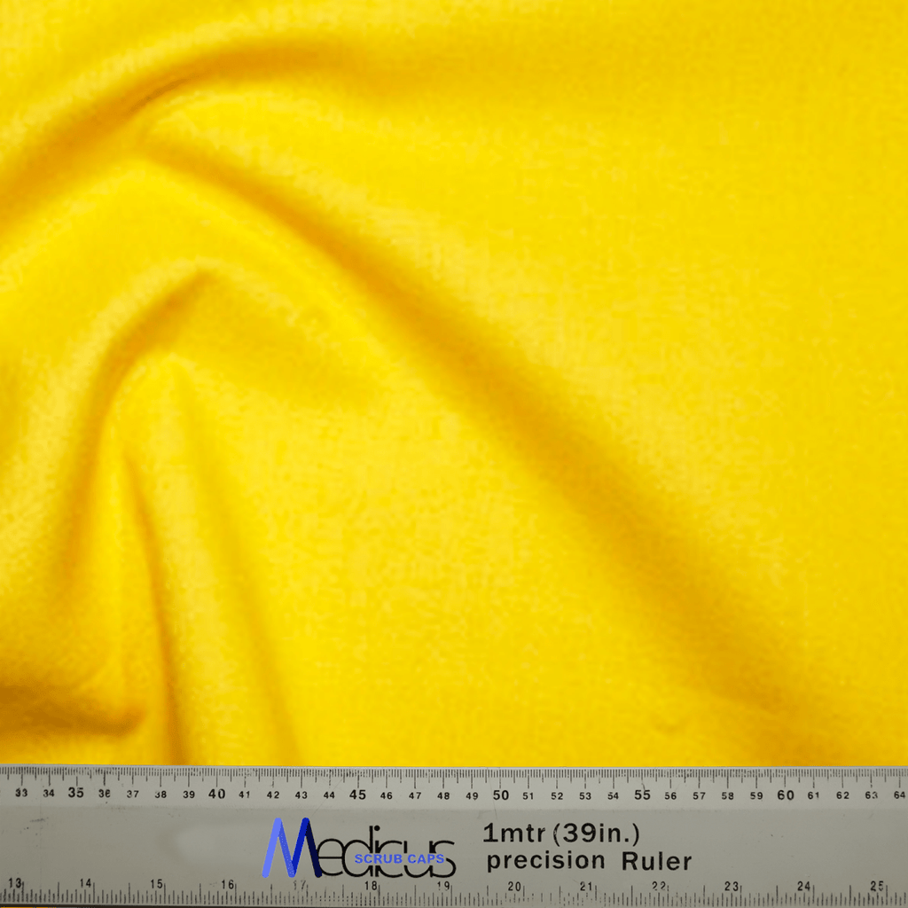 A vibrant Classic Plain Corn Yellow Scrub Cap by Medicus Scrub Caps is shown against a backdrop, with a ruler measuring one meter or 39 inches—perfect for ensuring a precise fit or designing a stylish theatre hat.