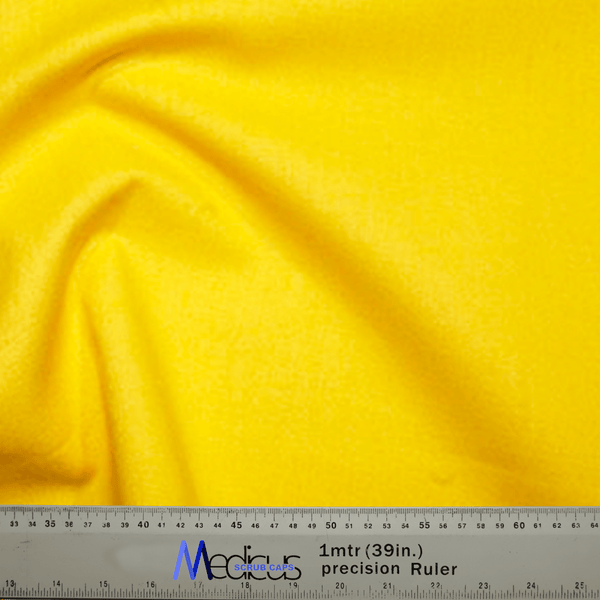 A vibrant Classic Plain Corn Yellow Scrub Cap by Medicus Scrub Caps is shown against a backdrop, with a ruler measuring one meter or 39 inches—perfect for ensuring a precise fit or designing a stylish theatre hat.