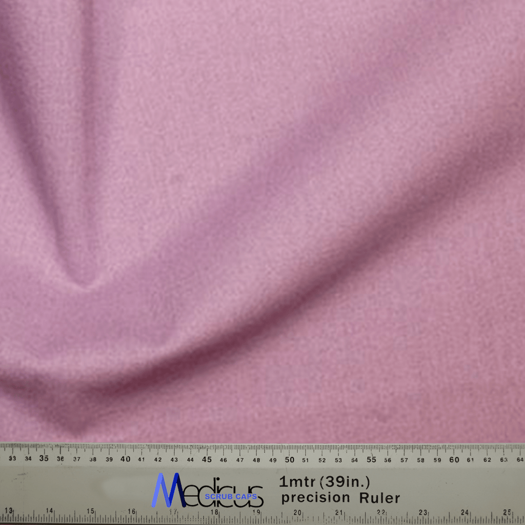 A close-up of the Classic Plain Lavender Purple Scrub Cap by Medicus Scrub Caps shows its soft texture, gently gathered to the left. A ruler at the bottom displays measurements in both centimeters and inches for a perfect fit.