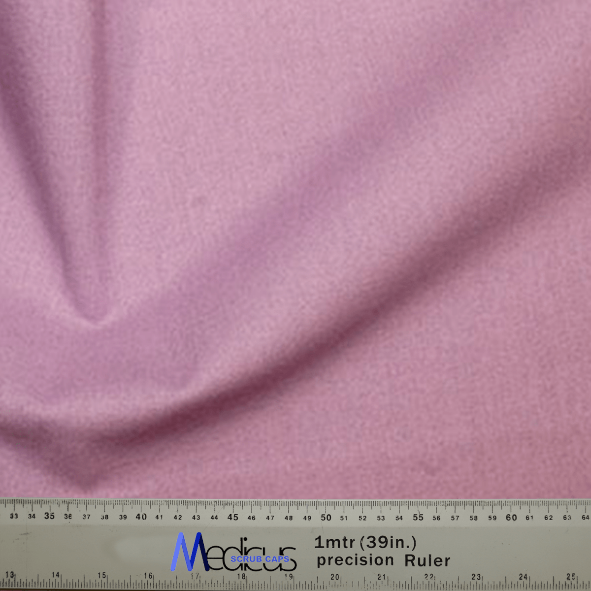 A close-up of the Classic Plain Lavender Purple Scrub Cap by Medicus Scrub Caps shows its soft texture, gently gathered to the left. A ruler at the bottom displays measurements in both centimeters and inches for a perfect fit.