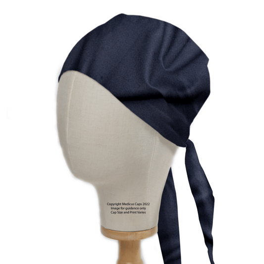 Displayed on a mannequin with a light-colored face, the Classic Plain Navy Scrub Cap by Medicus Scrub Caps is tailored for a custom fit, featuring two long straps tied at the back. The mannequin stands elegantly on a wooden base, perfect for showcasing this healthcare staple.