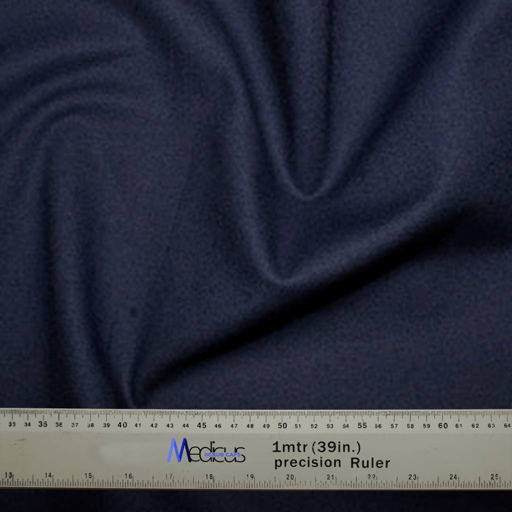 A Classic Plain Navy Scrub Cap from Medicus Scrub Caps, with visible folds, is shown with a gray precision ruler measuring up to 1 meter (39 inches) labeled Medicus, highlighting the attention to detail appreciated by healthcare professionals for achieving a custom fit.
