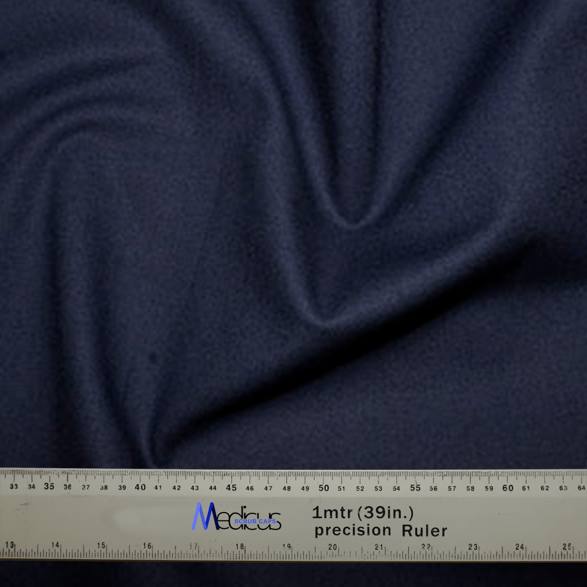 A Classic Plain Navy Scrub Cap from Medicus Scrub Caps, with visible folds, is shown with a gray precision ruler measuring up to 1 meter (39 inches) labeled Medicus, highlighting the attention to detail appreciated by healthcare professionals for achieving a custom fit.