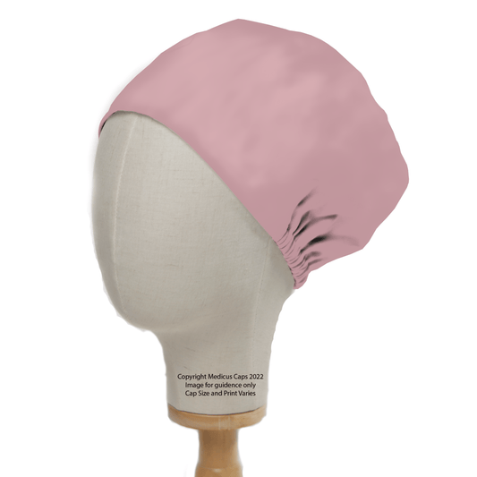 The Classic Plain Pale Pink Scrub Cap by Medicus Scrub Caps is displayed on a mannequin head. Its a favorite among healthcare professionals, offering a sleek fit gathered at the back. The cap stands elegantly on a simple wooden base and is perfect for bulk discounts.