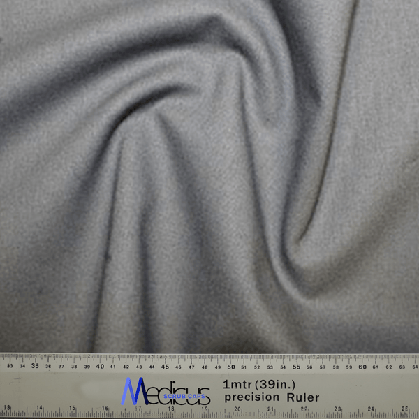 A close-up of the Classic Plain School Grey Scrub Cap fabric by Medicus Scrub Caps showcases a swirling pattern, perfect for crafting durable scrub caps. Below is a precision ruler measuring 1 meter or 39 inches, featuring both centimeters and inches for healthcare professionals precise cutting needs.