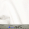 Close-up of a smooth, subtly folded white 100% cotton fabric by Medicus Scrub Caps. A one-meter precision ruler marked with centimeters and inches lies at the bottom. Ideal for crafting a Classic Plain White Scrub Cap or Theatre Hat.