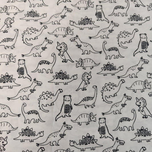 The Colour Me In Scrub Cap by Medicus Scrub Caps features a playful pattern of cartoon dinosaurs outlined in black on a white background, perfect for adding a stylish and hygienic touch.