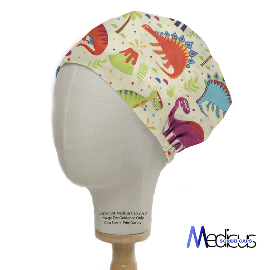 A mannequin displays the Colourful Dinoland Scrub Cap from Medicus Scrub Caps, featuring vivid cartoon dinosaurs in red, blue, green, and purple on a cream background. The playful design is completed with the brand logo in the bottom right corner of this reusable hat.