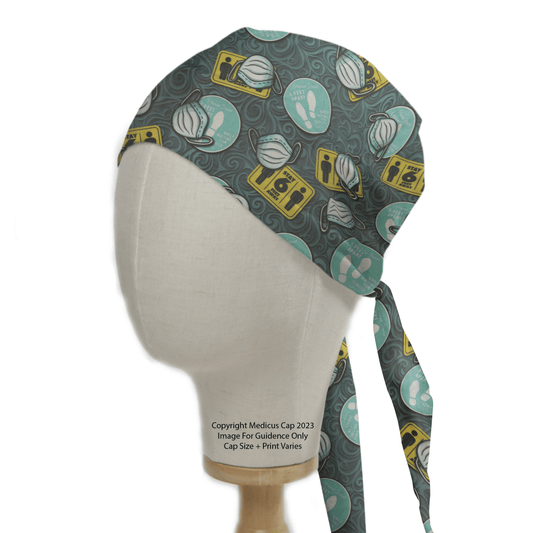 A mannequin head showcases the Medicus Scrub Caps Covid Masks Social Distancing Scrub Cap with medical-themed prints such as Covid masks, soap, and social distancing icons in teal, white, and yellow on a dark gray background. The straps are tied at the back.