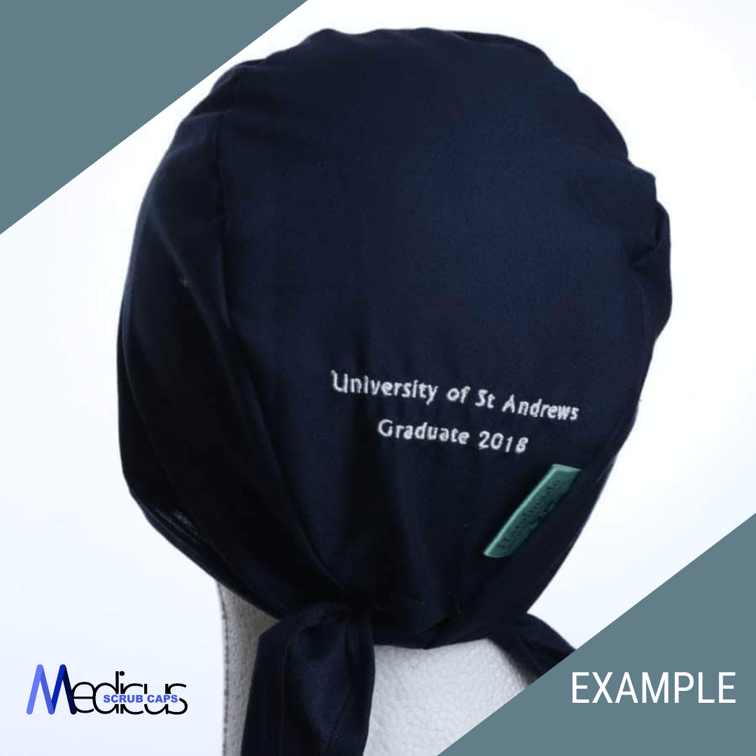 A mannequin displays a dark blue Custom Scrub Cap With Personalised Embroidery, reading University of St Andrews Graduate 2018. Made from high-quality fabric with a back tie, it features the Medicus Scrub Caps logo on the bottom left corner.