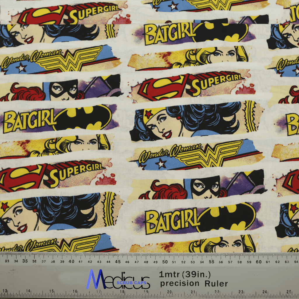 The Medicus Scrub Caps DC Comic Superhero Women Comic Strip fabric displays Batgirl, Supergirl, and Wonder Woman in vibrant colors, perfect for crafting a scrub cap for DC Comics fans. A ruler at the bottom shows measurements in centimeters and inches.