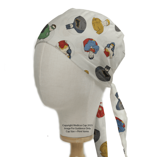 A mannequin head displays a Medicus Scrub Cap, the DC Universe Character Circles White Scrub Cap, featuring colorful superhero illustrations and a tie-back design.