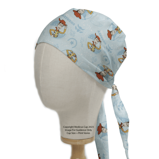 The Medicus Scrub Caps Disney Pixar Toy Story Woody Sheriff Blue features a light blue scrub cap, adorned with Woody and other cartoon cowboys and cowgirls. It showcases themed motifs on a mannequin head, with its ties elegantly draping down the side.