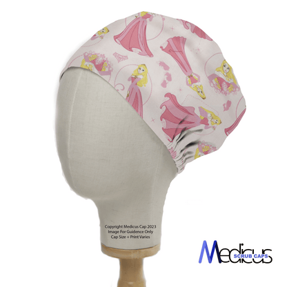 A mannequin head wears a Disney Princess Sleeping Beauty Scrub Cap featuring a princess in a pink gown, flowers, and birds on a light background. The Medicus Scrub Caps logo is in the bottom right, highlighting sustainable healthcare fashion.