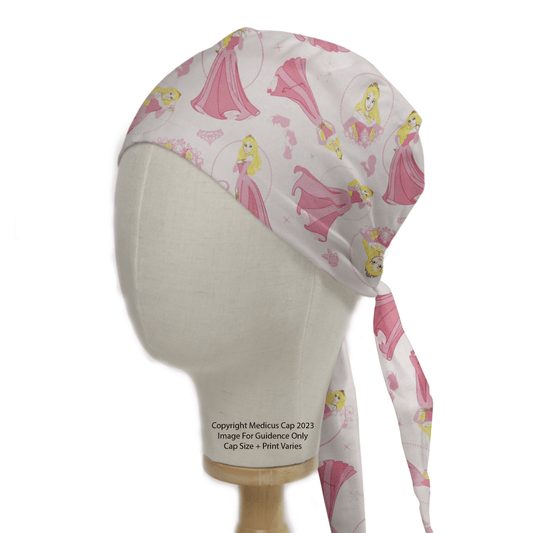 The mannequin wears the Disney Princess Sleeping Beauty Scrub Cap by Medicus Scrub Caps, a pink reusable cap ideal for sustainable healthcare. It features illustrations of a princess in a flowing dress and has convenient back ties for secure wear.