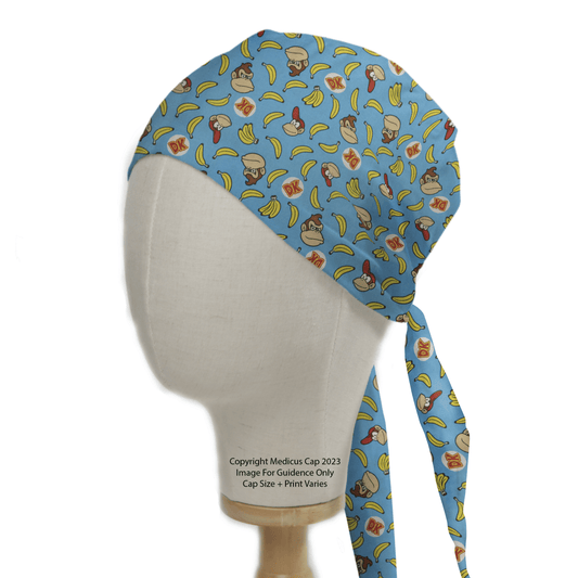 A mannequin head displays the DK Donkey Kong Bananas Blue Scrub Cap from Medicus Scrub Caps, featuring a fun pattern of DK logos, monkeys, and bananas.