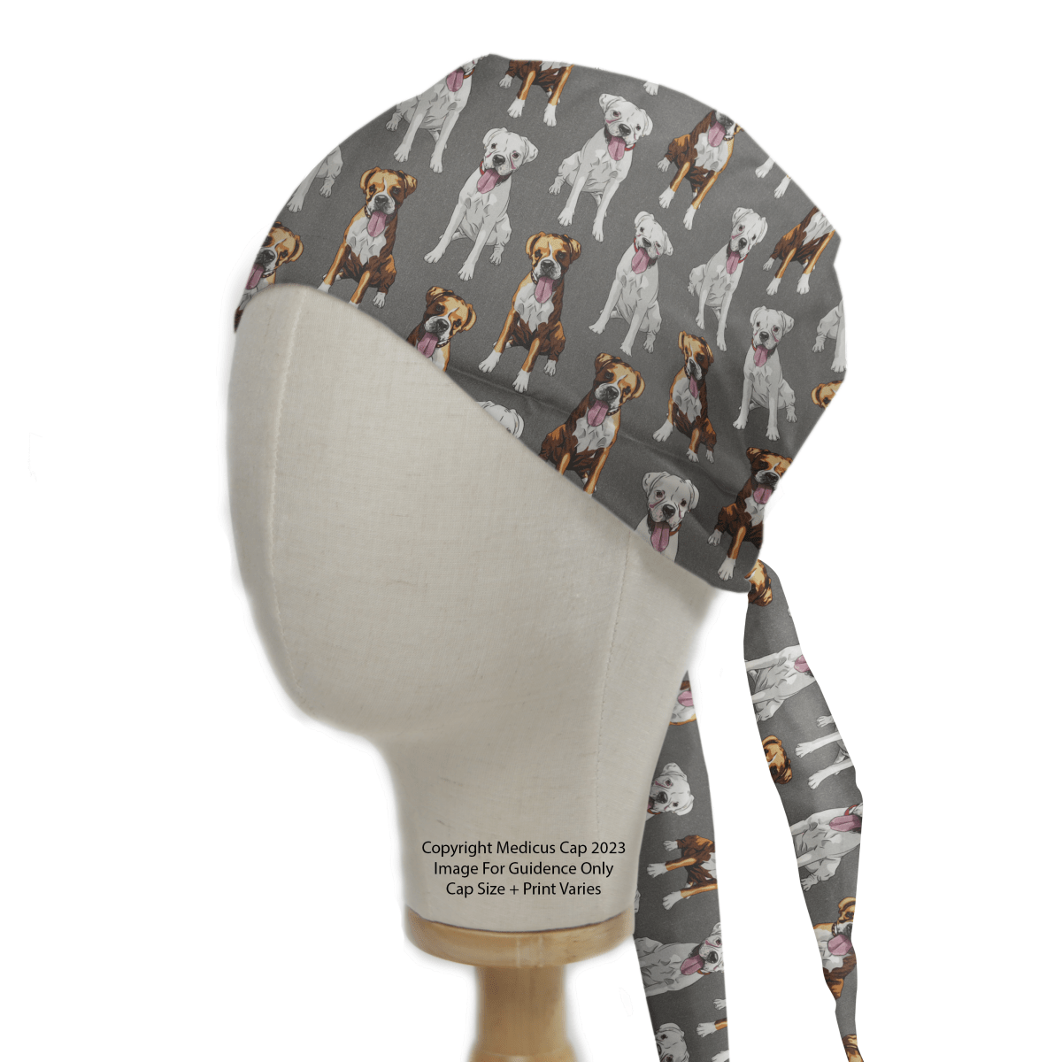 The Medicus Scrub Caps Dog Breeds Boxers Grey Scrub Cap features a playful dog pattern, including Boxers with white and brown spots. Designed for an adjustable fit, it is charmingly displayed on a mannequin head.