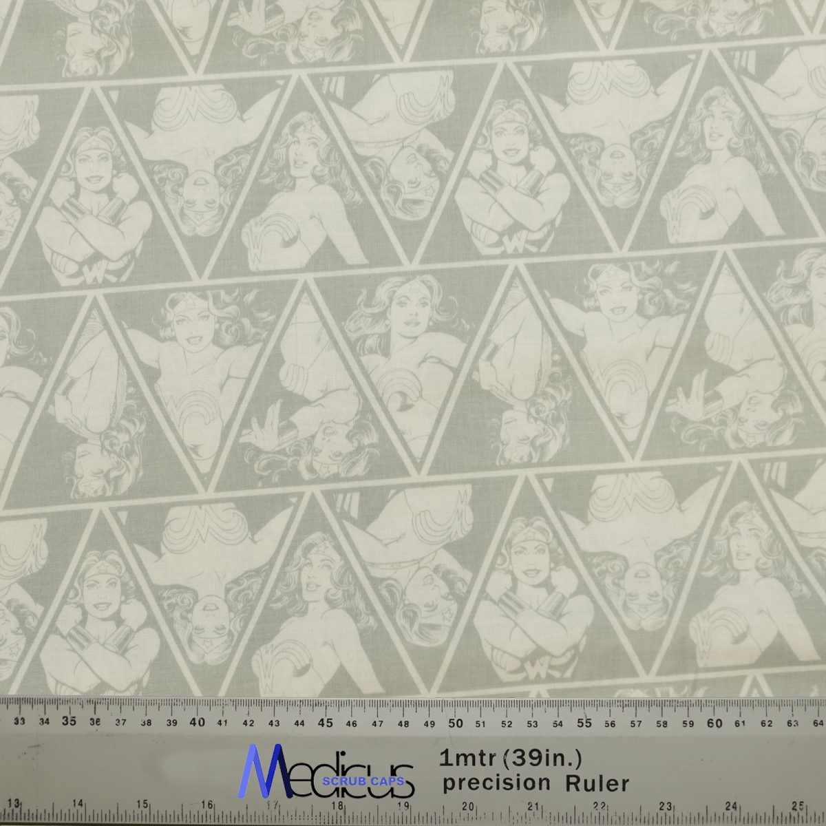 The Faded Wonder Woman Diamonds Scrub Cap by Medicus Scrub Caps features a repeated triangle pattern with comic-style superhero portraits on a gray backdrop. With long hair and star motifs, theyre perfect for celebrating healthcare heroes. A ruler at the bottom aids in precise crafting.